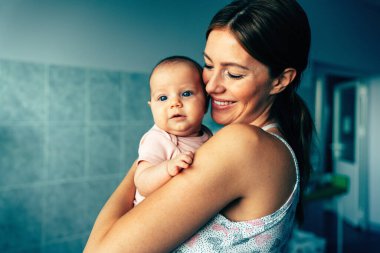 Neşeli aile kavramı. Anne ve bebek öpüşüyor, gülüyor ve sarılıyor.