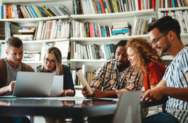 Gülümseyen çeşitli meslektaşlar toplantı odasında toplanmış mali istatistikleri tartışıyorlar. Mutlu çok ırklı iş arkadaşları ofis toplantılarında işbirliği yaparken eğleniyorlar. Takım çalışması konsepti.