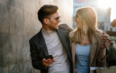 Genç başarılı mutlu çift şehirde birlikte eğleniyor. Alışveriş randevusu iş seyahati konsepti.