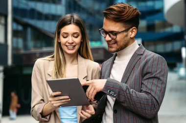 İş adamları, şehir planındaki işyerinde eğleniyor, çalışıyor ve sohbet ediyorlar.