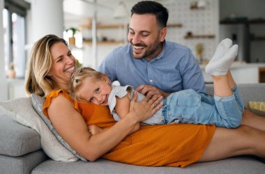 Mutlu genç aile evde eğleniyor. Ebeveynler, çocuklar mutluluk kavramını sever.