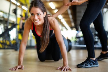 Güzel, formda bir kadın spor salonunda kişisel antrenörüyle egzersiz yapıyor. Spor, insanların kavramı