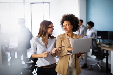 Mutlu çoklu etnik çeşitlilikte gülümseyen iş kadınları ofiste birlikte çalışıyor. Şirket başarısı konsepti