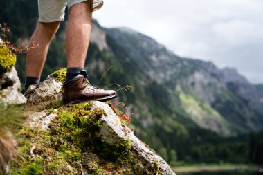 Maceraperest adam sırt çantasıyla dağda yürüyüş yapıyor, açık hava yaşam tarzı tatilinde..