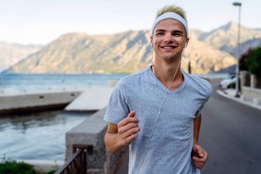 Aktif, formda koşan erkek koşucu sağlıklı kalmak için dışarıda koşuyor. Spor insanları egzersiz konsepti