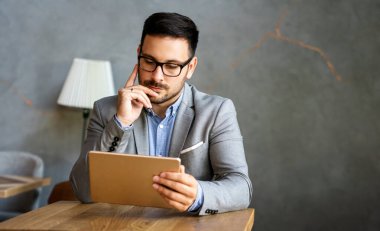 Dijital tablet üzerinde çalışan genç iş adamının portresi. İş insanları teknoloji kavramı