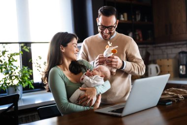 Evde dizüstü bilgisayarı olan, çocuklu neşeli bir aile. Aile mutluluk teknolojisi kavramı.