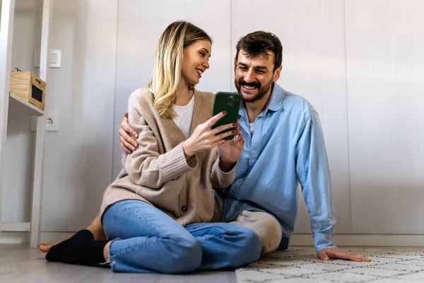 快乐的年轻夫妇 男女拥抱在一起 一起用智能手机 妻子和丈夫看着手机屏幕 喜形于色 社交媒体概念 — 图库照片