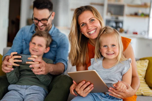 Ευτυχισμένη Οικογένεια Περνάει Χρόνο Στο Σπίτι Και Χρησιμοποιεί Ψηφιακές Συσκευές — Φωτογραφία Αρχείου