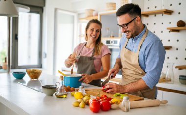 Çekici genç çift mutfakta organik sağlıklı yiyecekler pişiriyor..