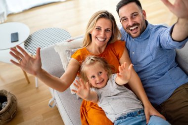 Mutlu genç aile evde eğleniyor. Ebeveynler, çocuklar mutluluk kavramını sever.