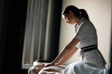 Güzellik salonunda masaj yaptıran genç bir kadın.