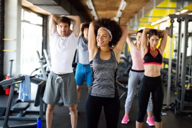 Sağlıklı kalmak için spor salonunda egzersiz yapan bir grup sağlıklı genç. Spor, insanların kavramı.