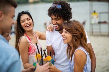 Plajda kokteyl içip yaz tatilinde eğlenen arkadaşlar. İnsanların mutluluk kavramı