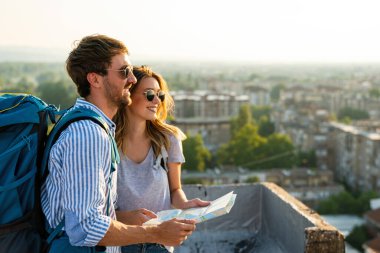 Tatil gezisinde haritalı mutlu bir çift. İnsanlar seyahat ederken aşk konsepti.