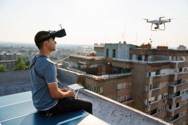 Uzaktan kumandalı insansız hava aracı uçuran genç teknisyen.