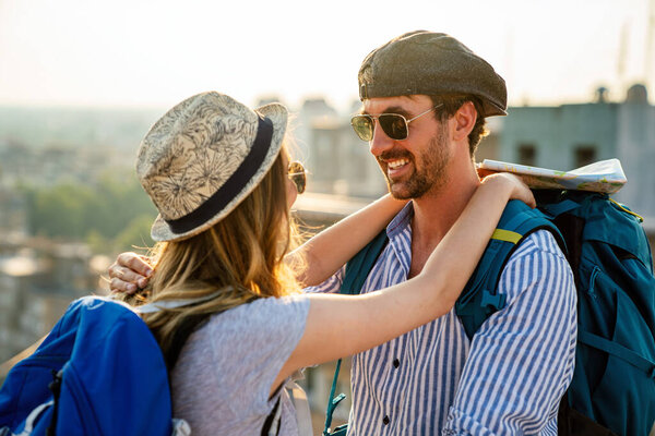 Happy tourists couple, friends sightseeing city with map together. Travel people fun concept.