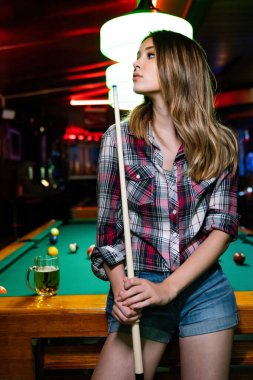 Genç güzel kız bilardo oynuyor. Keyifli zaman geçirme, dinlenme, eğlence konsepti