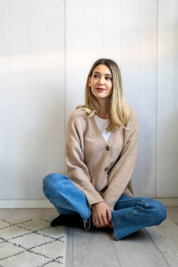 Mutlu gülümseyen hippi kadın evde yerde oturuyor. İnsanlar mutluluk konsepti yapar