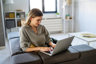 Sosyal medya ve rahatlama için dizüstü bilgisayar kullanan gülümseyen güzel bir kadın. İnsan teknolojisi kavramı.