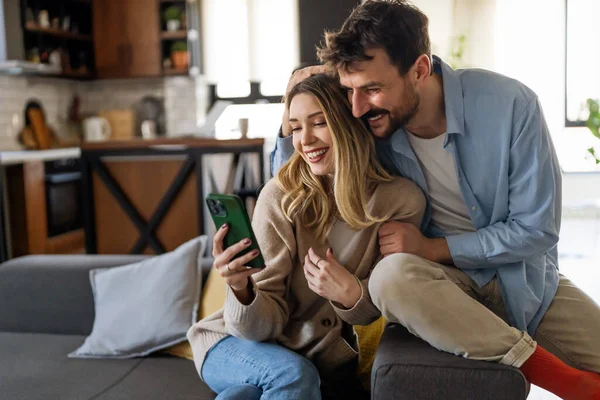 Lächelndes Junges Paar Das Sich Umarmt Während Auf Sein Smartphone — Stockfoto