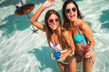 Mutlu genç seksi kadın arkadaşlar plajda yaz tatilinin tadını çıkarıyorlar. İnsanlar tatil eğlencesi konsepti ile seyahat eder