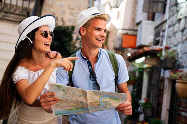 旅行和旅游的概念 在城市里带着地图微笑的夫妻 — 图库照片