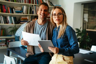 Bir grup çok ırklı genç meslektaşın toplantı sırasında şirketin mali evrakları hakkında konuşuyorlar. Takım çalışması konsepti. Çeşitli iş arkadaşları birlikte çalışıyor..