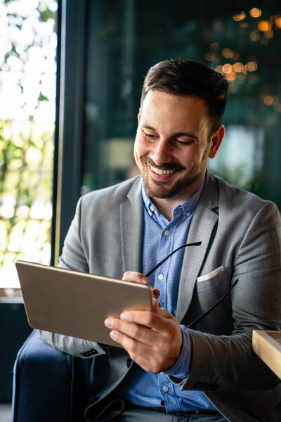 Portrait of happy succeffsul young business man, leader, ceo, manager using digital tablet to work. Business technology concept.