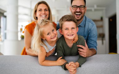 Mutlu genç aile evde eğleniyor. Ebeveynler, çocuklar mutluluk kavramını sever.