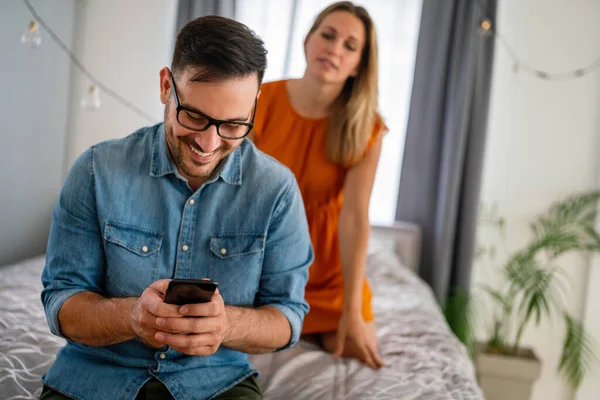 嫉妬深い若い女性はボーイフレンドをスパイし 彼の携帯電話を見て カップル浮気嫉妬の概念 — ストック写真