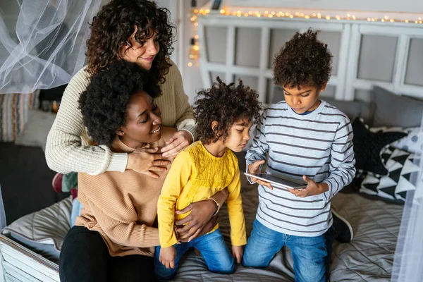 同性愛者の両親と小さな子供たちと一緒にデジタルタブレットを使用して楽しいデジタルデバイスを持っている幸せな多民族家族 — ストック写真