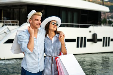 Alışveriş torbalarıyla mutlu bir çiftin portresi. İnsanlar tüketicilik tatil seyahati yaşam tarzı konsepti satıyor.