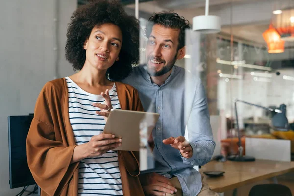 stock image Smiling group of diverse businesspeople going over paperwork together and working in corporate office. Business teamwork concept.