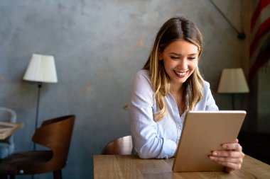 Güzel başarı genç bayan dijital tablet kullanarak çalışıyor. İş, serbest meslek, sosyal medya kavramı.