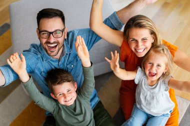 Mutlu genç aile evde eğleniyor. Ebeveynler, çocuklar mutluluk kavramını sever.