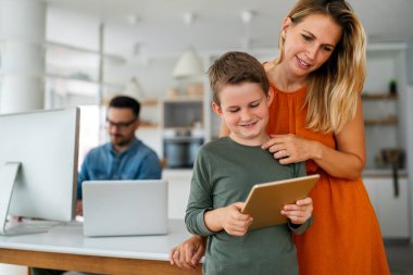 Anne ve çocuğun e-öğrenim için dijital tablet kullanan portresi. Eğitimde evde eğitim veren dijital cihaz çocuk kavramı.