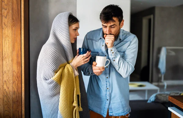 被舒适的毛毯包裹着的一对冻结的夫妇 男人和女人裹在温暖的毯子里 在寒冷的房间里 — 图库照片