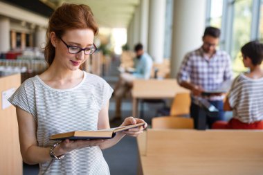 Bir kolej kütüphanesinde birlikte çalışıp çalışan bir grup başarılı öğrenci. Eğitim insanları öğrenme kavramı.