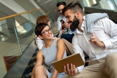 Genç iş adamlarından oluşan mutlu bir grup arkadaş toplantıda fikir alışverişinde bulunuyor. İş takım çalışması konsepti.