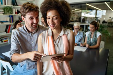 Bir grup başarılı çok ırklı iş adamı konferansta ve modern ofiste birlikte çalışıyorlar.