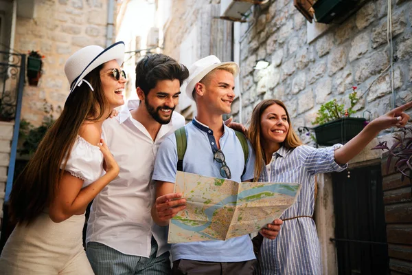 Happy traveling student tourists sightseeing with map in hand