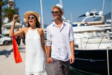 Güzel, genç bir çift alışveriş çantaları taşıyor ve seyahatin tadını çıkarıyor, birlikte tatile çıkıyorlar. Tüketim, insanlar seyahat konsepti.