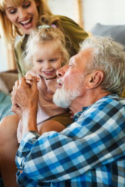 Neşeli, çoklu kuşak bir aile evde birlikte vakit geçirirken eğleniyor. İnsanların mutluluk kavramı.
