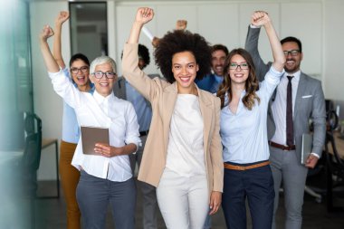 Bir grup başarılı, çok ırklı iş adamı ofiste iyi bir işi kutluyorlar.