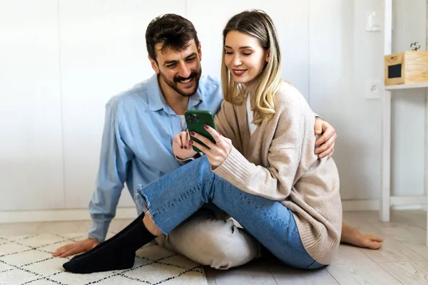 Lächelndes Junges Paar Das Sich Umarmt Während Auf Sein Smartphone — Stockfoto