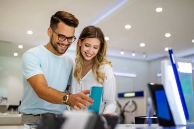 Yeni bir dijital cihaz alıyorum. Mutlu çift mağazadan akıllı telefon alıyor. Teknoloji sosyal medya insanları kavramı.