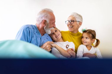 Torunlarını önemsemek, hastane koğuşunda geçirdiği tıbbi ameliyattan sonra dedesine sarılmak. Yaşlı adam klinik terapi sırasında yatakta dinleniyor. Sağlık hizmetleri desteği