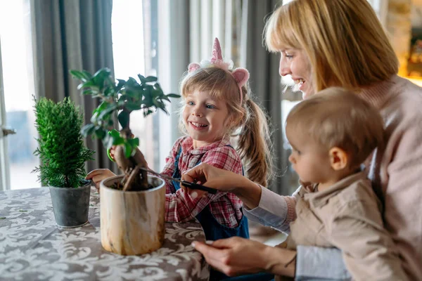 Nette Kinder Die Ihrer Mutter Bei Der Pflege Der Pflanzen — Stockfoto