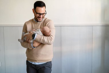 Yeni doğmuş bebeğini kucaklayan ve öpen bir babanın portresi. Erkek ebeveyn çocuğunu tutuyor. Otantik yaşam tarzı dokunaklı bir an. Bekar baba aile hayatı konsepti.